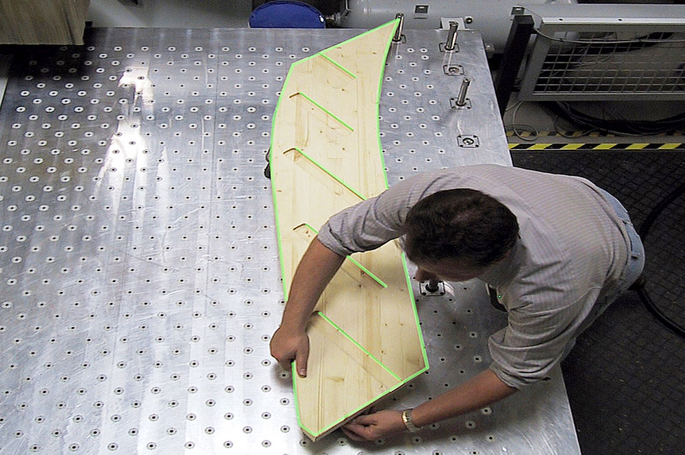 Mann an Messplatte mit Laserprojektion für die Holzbearbeitung