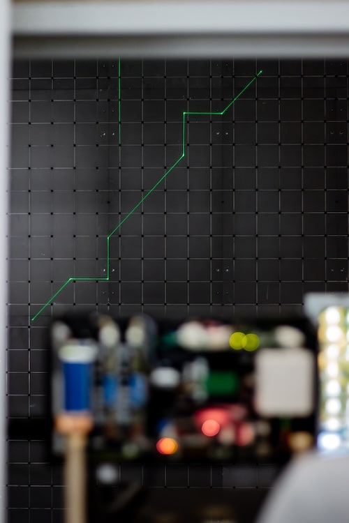 L'image montre une ligne laser verte sur un mur noir
