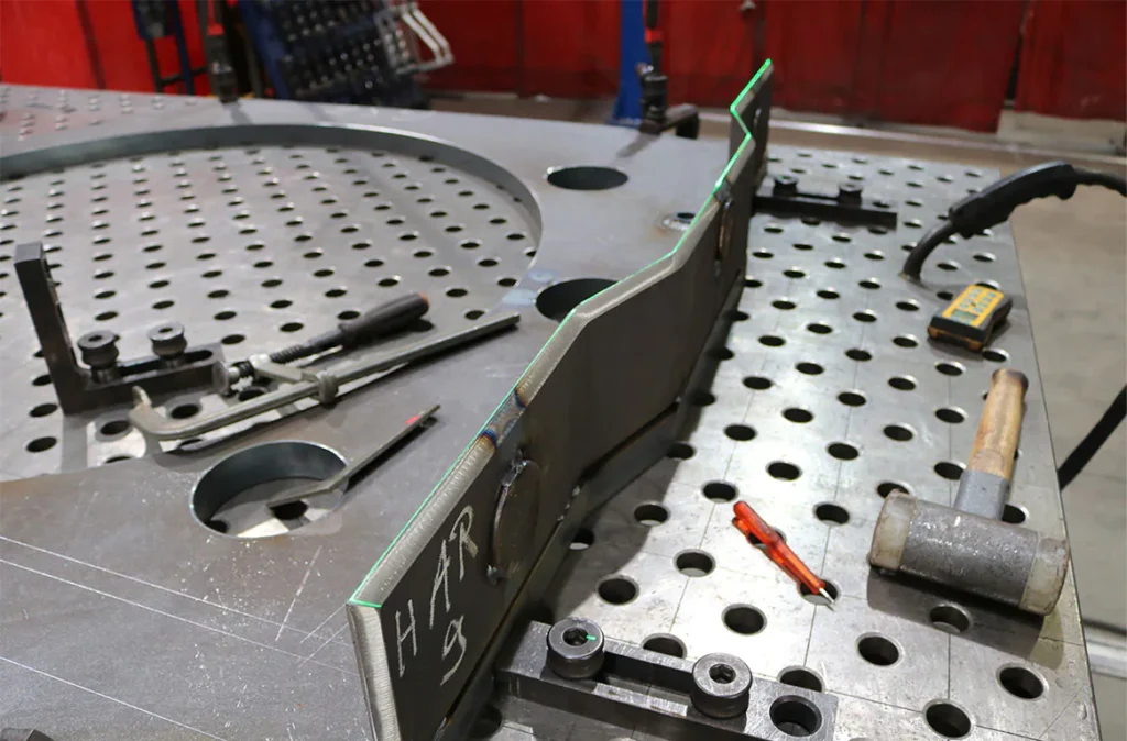 Grüne Linien zeigen die exakte Position für Metallbauteile auf dem Schweißtisch