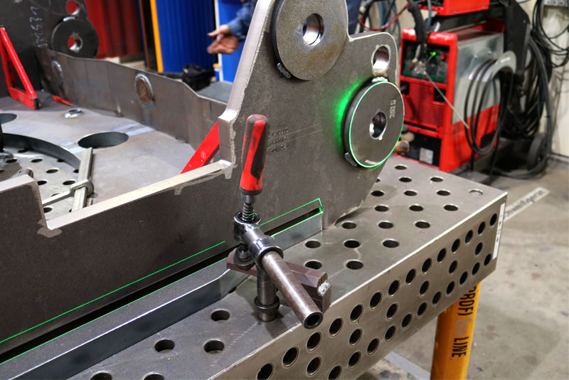 Metalworking on a workbench – green SL laser lines mark precise positions for welding and aligning components.