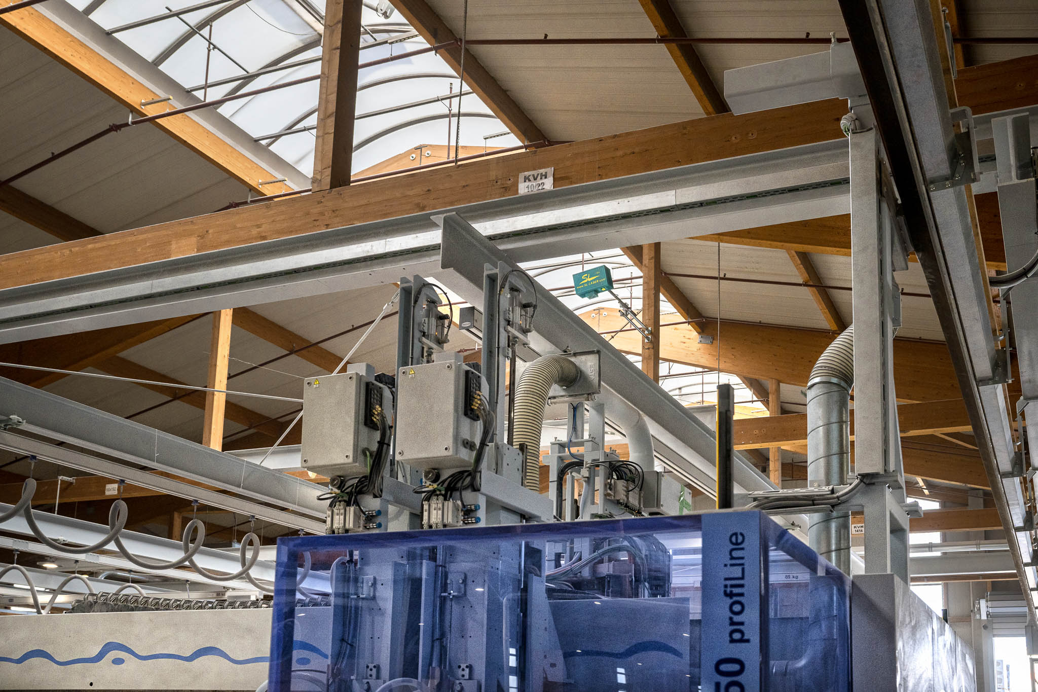 Le dispositif laser SL est monté sous le toit du hall et permet un positionnement précis sur un système de production automatisé.