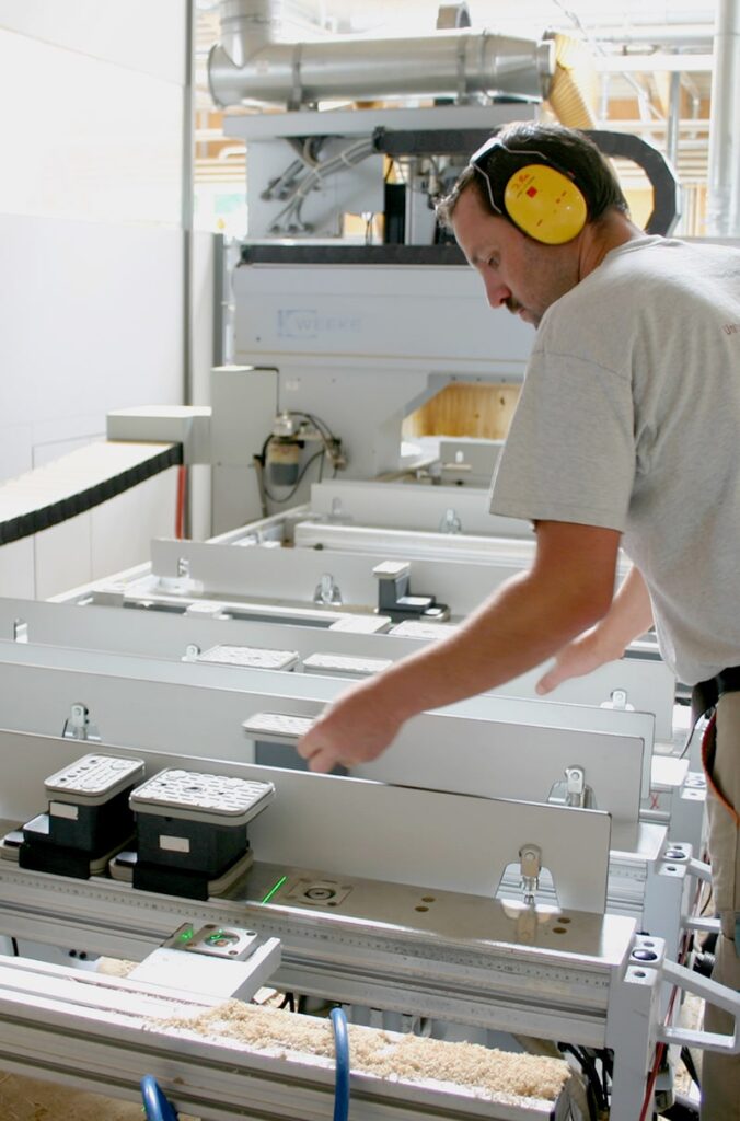 Employees in CNC woodworking – precise positioning of workpieces with SL-Laser laser projector for maximum precision.