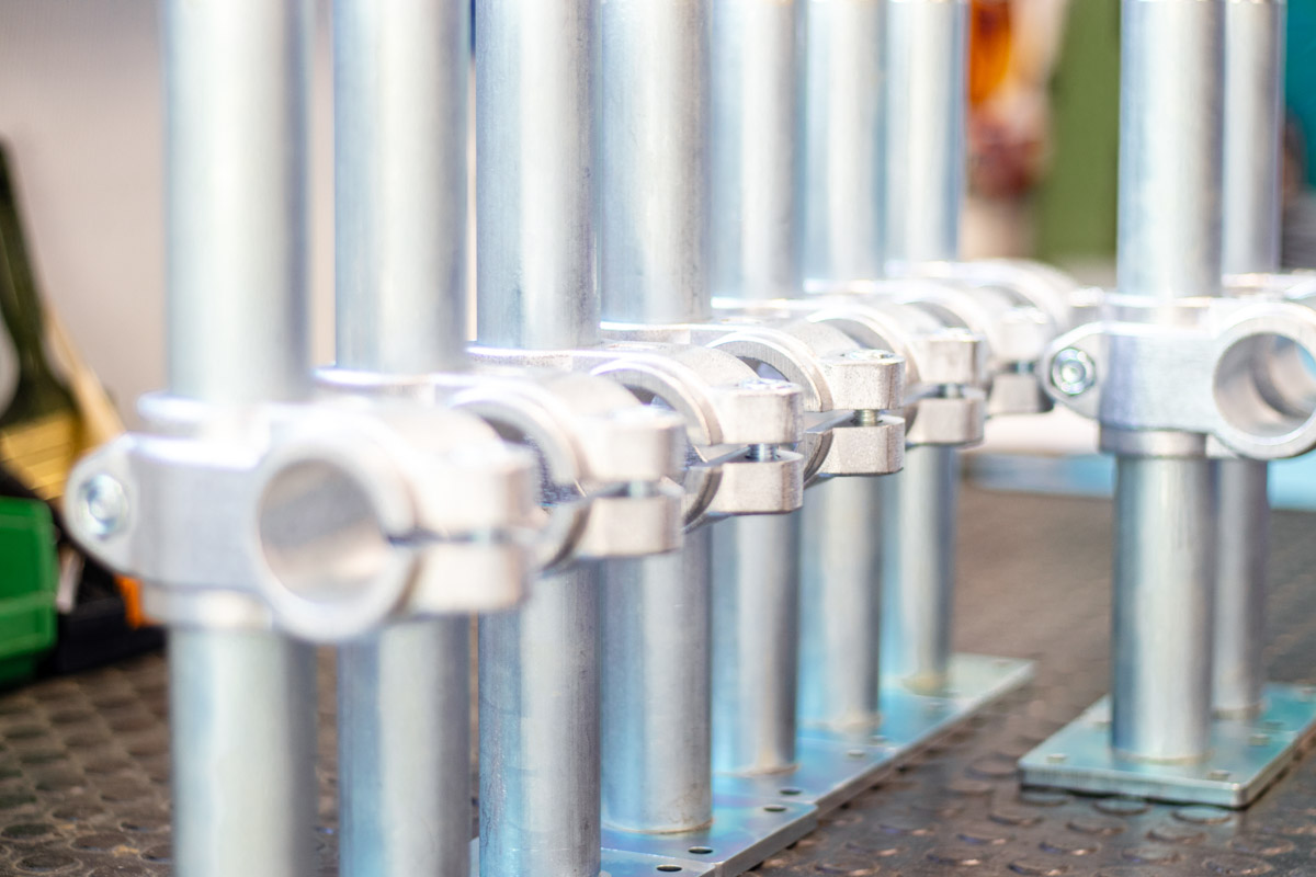 Series of metal tubes with sturdy support clamps, mounted on a base plate.