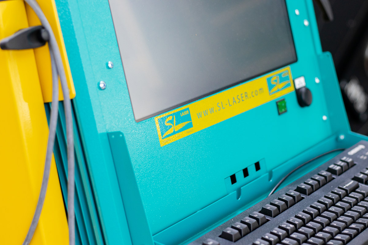Detailaufnahme einer SL-Laser Steuerungseinheit mit Bildschirm, Tastatur und Firmenlogo.