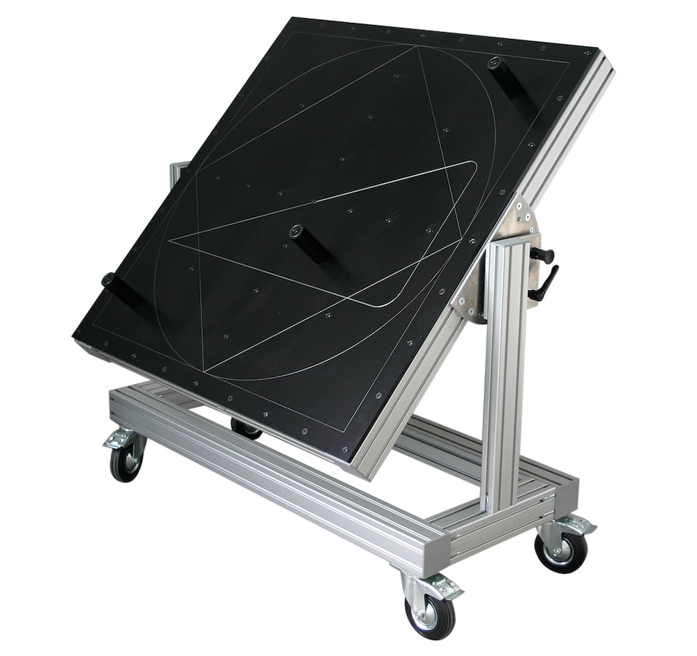 Black SL laser certification tool on a mobile aluminum frame – calibration system with markings for precise adjustment of laser projectors. Side, oblique view.