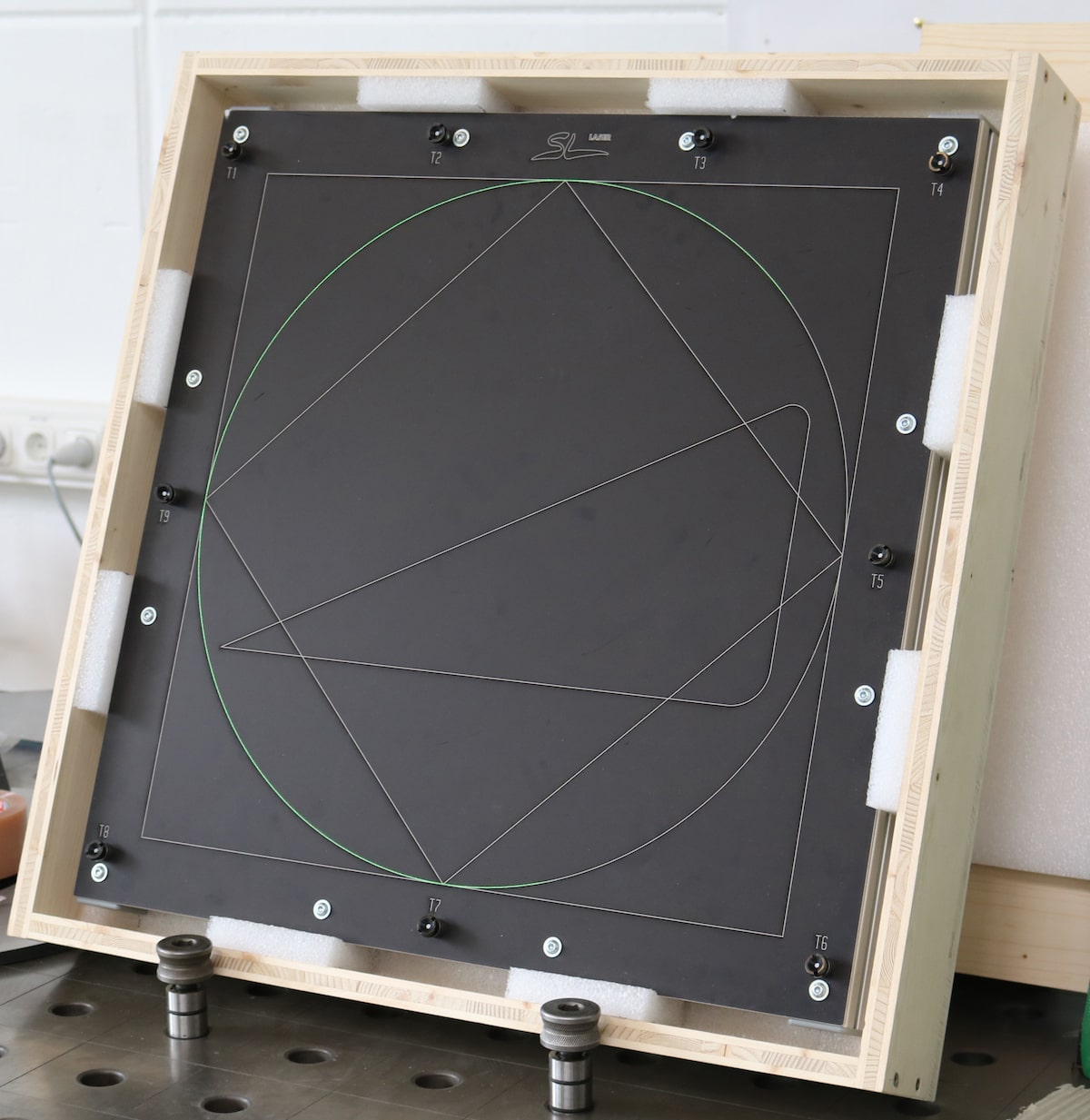 Black SL laser certification tool on a mobile aluminum frame – calibration system with markings for precise adjustment of laser projectors. View of milled contours.
