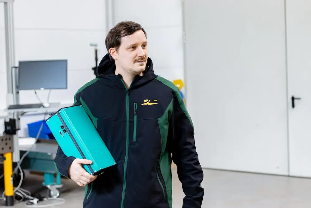 Employee carries a laser system through the production hall - mobile use of lasers in manufacturing