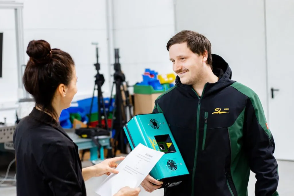 Two employees discussing an order with an SL Laser product